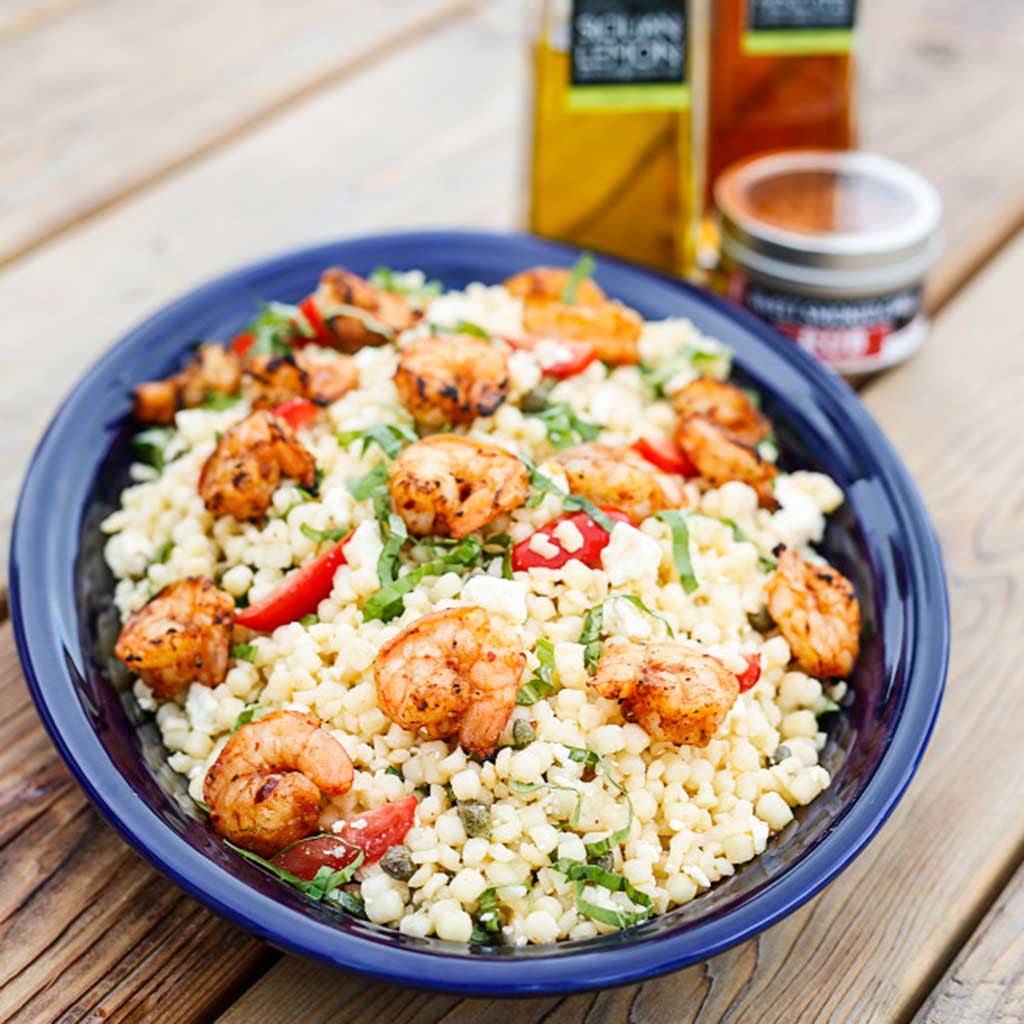 A colorful main dish of Spanish Grilled Shrimp Pasta Salad made with Sicilian lemon olive oil, sweet smoked chili rub and white balsamic vinegar served in a blue bowl.