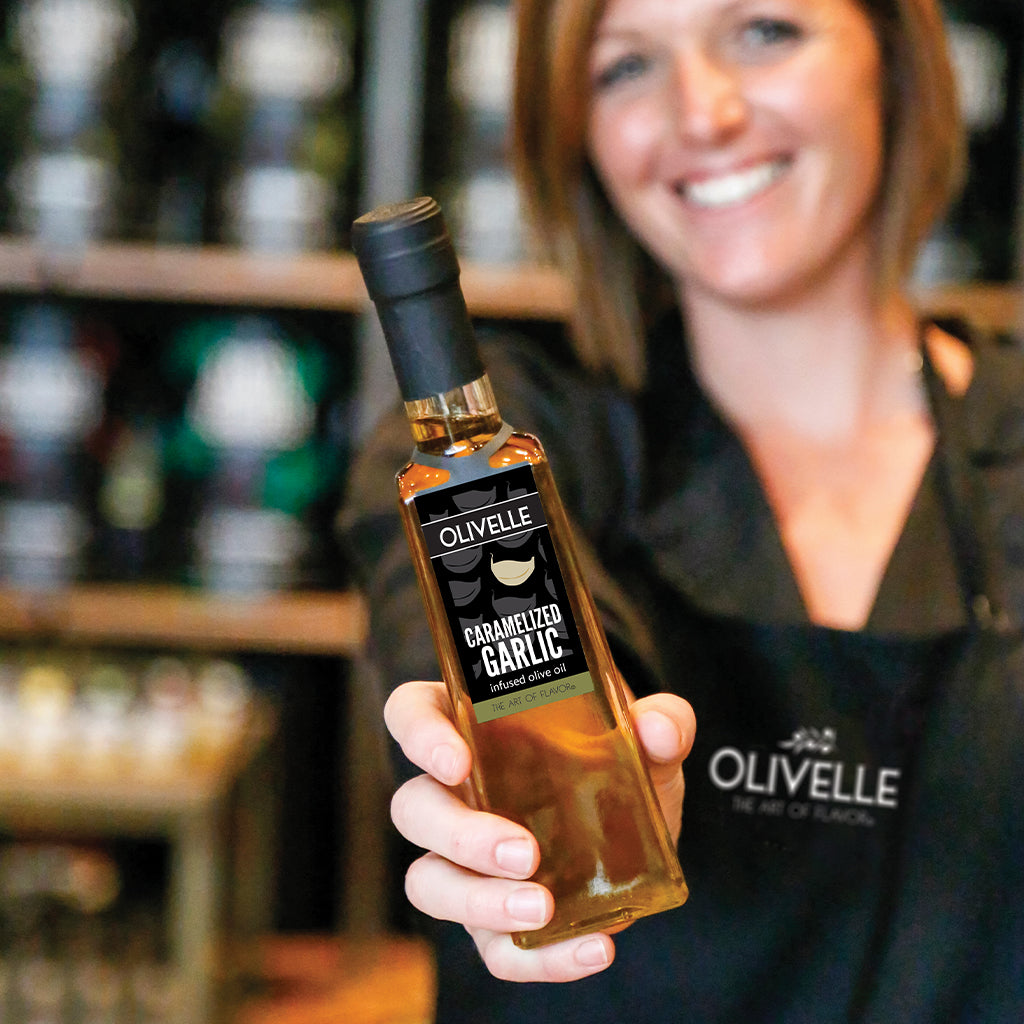 brie holding a bottle of caramelized garlic infused olive oil