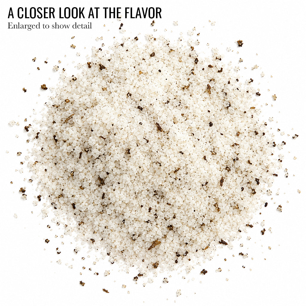 Close up of pale Black Truffle Infused Sea Salt flecked with dark specks with the words A Closer Look at the Flavor
