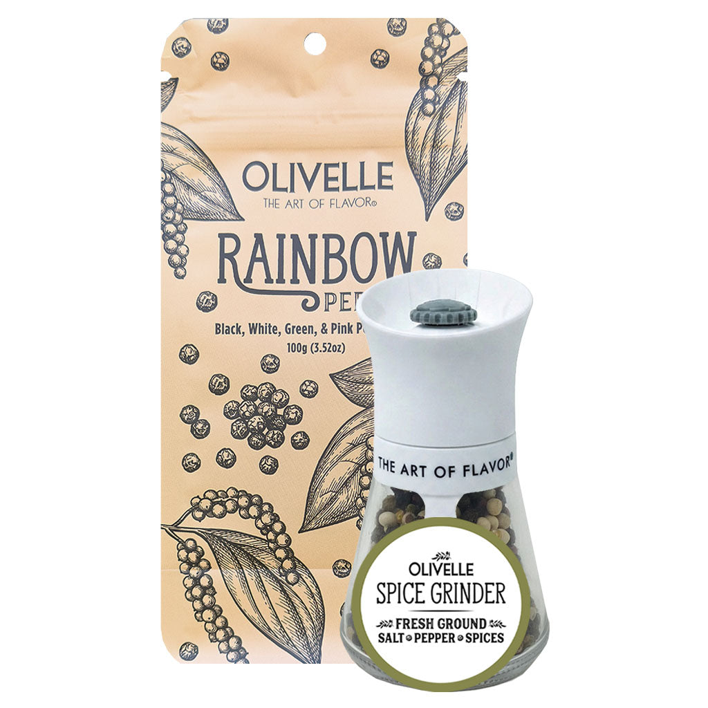 Olivelle Rainbow Pepper Salt and Spice Grinder set, featuring a white ceramic grinder filled with peppercorns in front of its beige packaging pouch decorated with botanical illustrations.