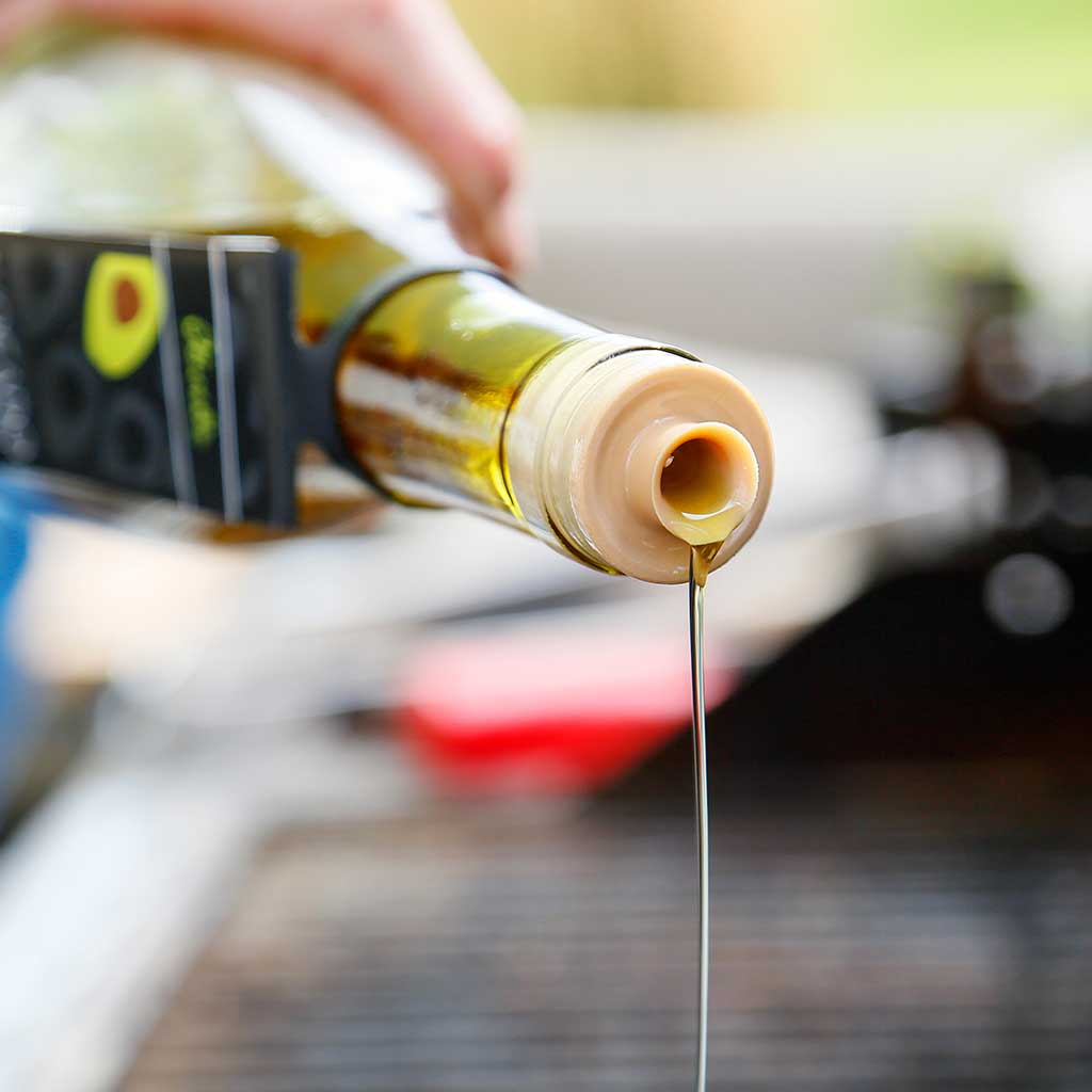 Avocado Oil being drizzled out of a glass jar using the Tapi Pour Spout